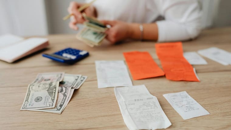 A business owner working through paperwork alone at a desk