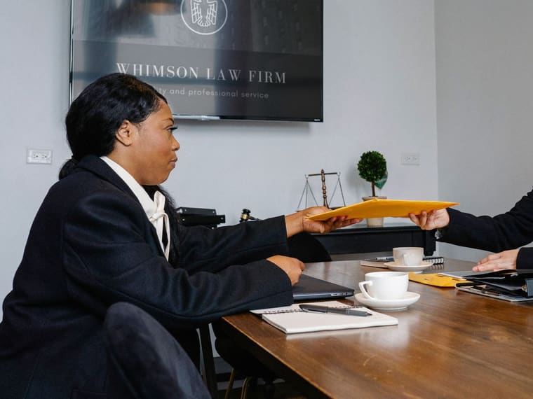 An attorney meeting a client across a desk in a law office