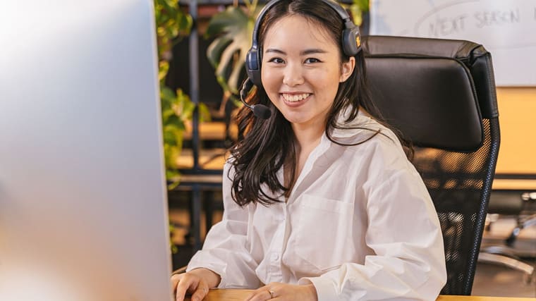 A professional taking a call on a headset at her desk